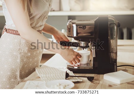 Woman making fresh espresso in coffee maker. coffee machine makes coffee. Barista Coffee Maker Machine Grinder Portafilter Concept Royalty-Free Stock Photo #733875271