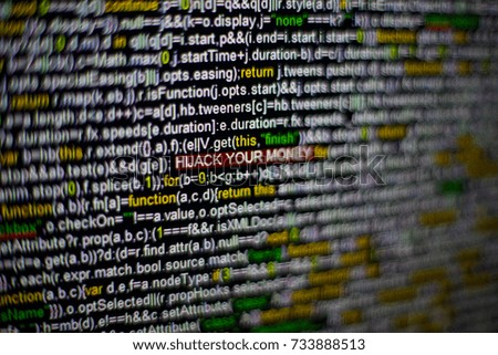 Macro photo of computer screen with program source code and highlighted HIJACK YOUR MONEY inscription in the middle. Script on the screen with virus in it. Cyber security concept. Technology