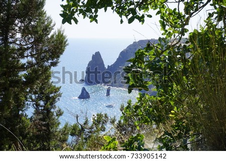 Monastery, Fiolent, Sevastopol, Crimea. Sharp rock-sail with boats in Black sea with green bushes on foreground. Natural colors photography. 