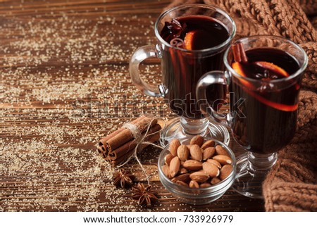 Mulled wine banner with glasses of hot red wine and spices on dark background. Closeup photography of warm alcohol drink in modern dark mood style.