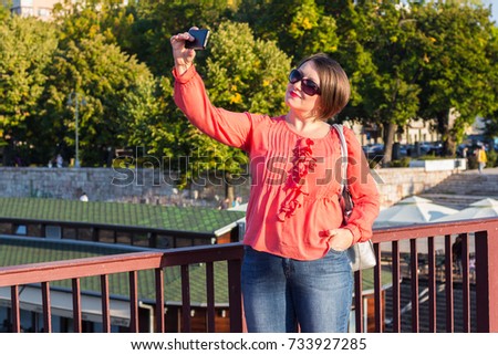 Young Woman With Sunglasses Standing on the Bridge and Taking Selfie