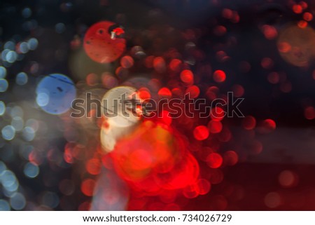 water drop on the obscured glass , raining drop and red color,  road light bokeh
Abstract urban defocused background, rain drops on car window. night city lights
