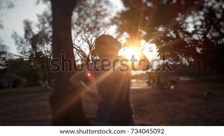 The sun shines through the woman drinking water after exercising in the park