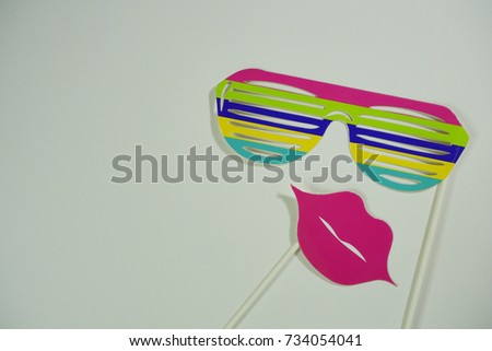 Top or flat lay view of Photo booth props a colorful stripe spectacles and pink lips on isolated white background flat lay. Birthday parties and weddings.