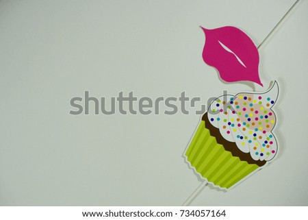 Top or flat lay view of Photo booth props a cupcake and a pink lips on isolated white background flat lay. Birthday parties and weddings.