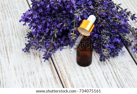 lavender oil with fresh lavender on a wooden background