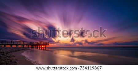 Panoramic picture of a sunset over wooden pier on the sea beach in Sarbinowo, Baltic Sea, Poland