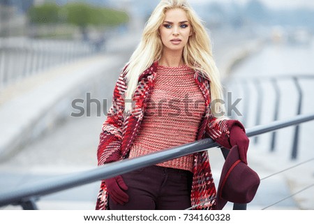 Cheerful smiling young woman on street. Beautiful fresh looking cute blonde girl outdoors at autumn. Street style concept