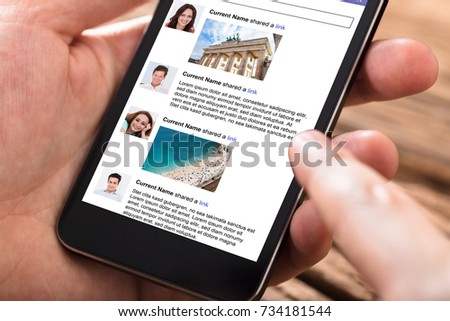 Close-up Of Person Using Mobile Phone For Surfing On Social Website