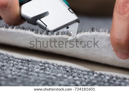 Carpenter Shaping Carpet Using Carpenter Tools To Lay Carpet At Home Royalty-Free Stock Photo #734181601
