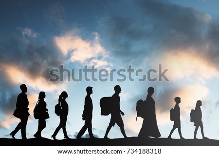 Silhouette Of Refugees People With Luggage Walking In A Row Royalty-Free Stock Photo #734188318