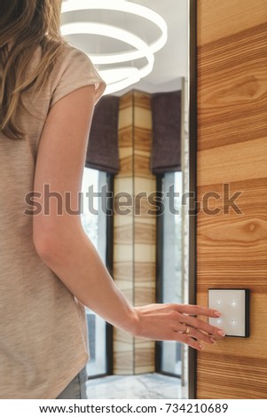 the girl turns on the light presses on the touch switch Royalty-Free Stock Photo #734210689