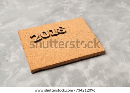 2018 on the cork board over the grey concrete background