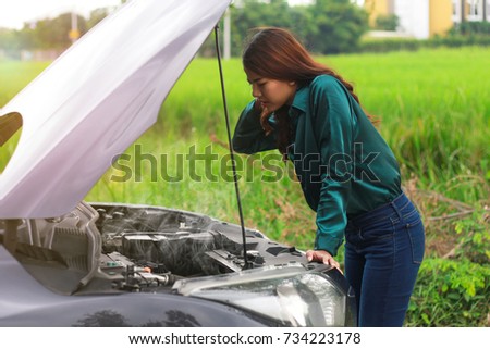 Car trouble, asian women worry and stress a trouble with car engine crash overheat, women are stressed with broken car and the smoke out of the hood,about broken car. About insurance. Royalty-Free Stock Photo #734223178