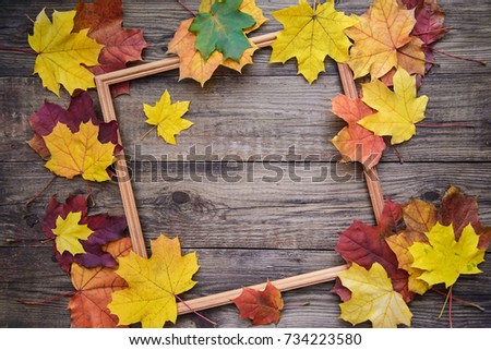 Beautiful autumn picture with yellow and red maple leaves frame on wooden background