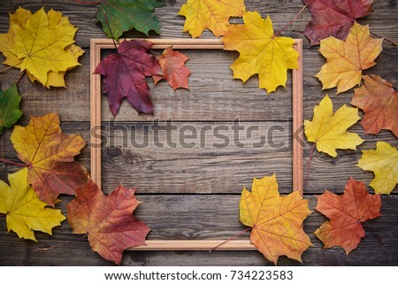 Beautiful autumn picture with yellow and red maple leaves frame on wooden background