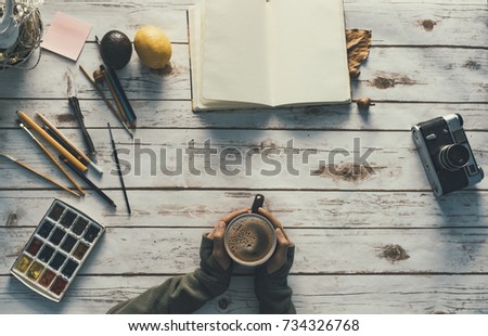 Girl with a cup of coffee and a creative work space