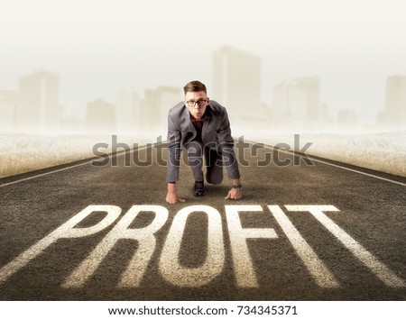 Young determined businessman kneeling before profit sign