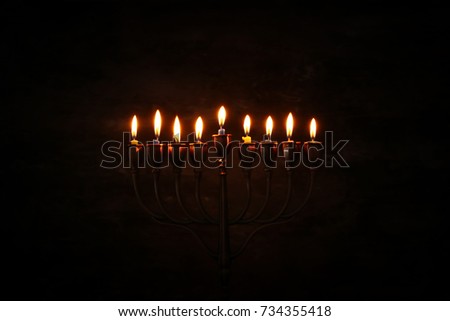Low key image of jewish holiday Hanukkah background with menorah (traditional candelabra) and burning candles.