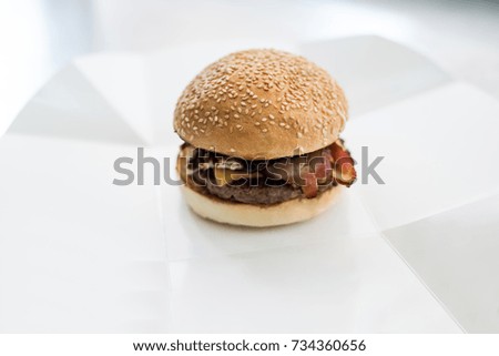 Juicy hot burger close-up. It lies on a white table