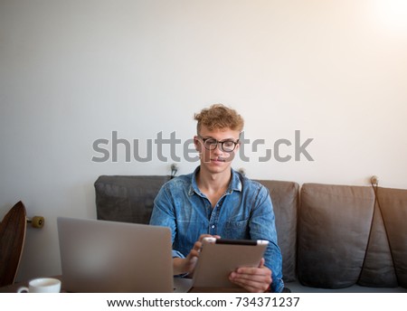 Confident man experienced business writer for executive summary using for work digital tablet and laptop computer. Young hipster guy working in coffee shop with touch pad and portable net-book