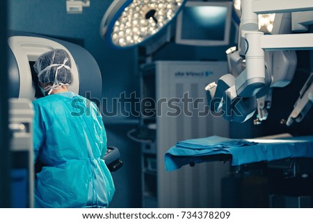 Surgical room in hospital with robotic technology equipment, machine arm surgeon in futuristic operation room. Minimal invasive surgical inoovation, medical robot surgery with 3D view endoscopy Royalty-Free Stock Photo #734378209