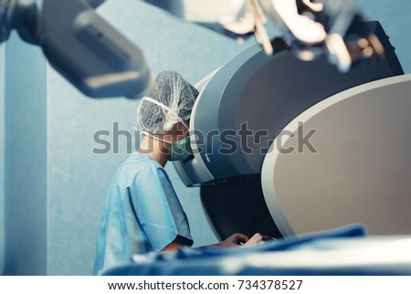 Surgical room in hospital with robotic technology equipment, machine arm surgeon in futuristic operation room. Minimal invasive surgical inoovation, medical robot surgery with 3D view endoscopy Royalty-Free Stock Photo #734378527