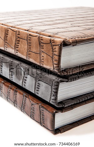 The pile of three leather photo books on white isolated backround