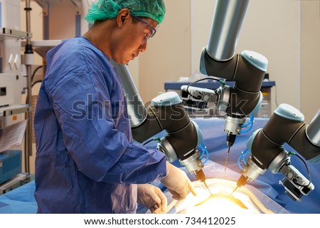 Smart precision healthcare technology , artificial intelligence concept. Automation robot hand machine in operating room and surgery doctors in futuristic hospital. Royalty-Free Stock Photo #734412025