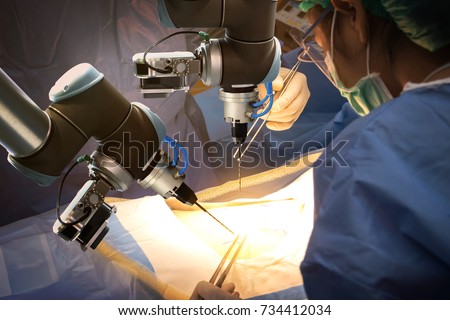 Smart precision healthcare technology , artificial intelligence concept. Automation robot hand machine in operating room and surgery doctors in futuristic hospital. Royalty-Free Stock Photo #734412034