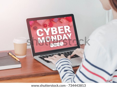 Young Asian woman shopping online with laptop display cyber Monday screen in home office or co working space.Concept of e-commerce using online technology.