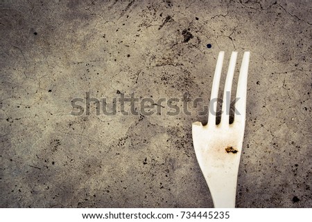 Broken melamine fork on a cement floor 