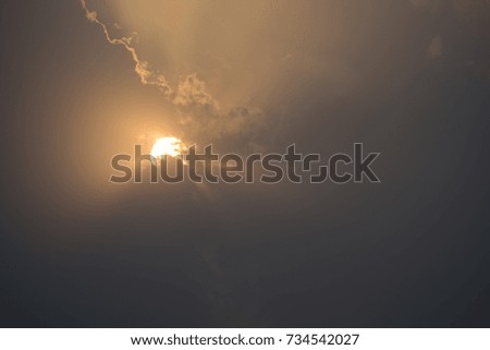Sun rising through clouds