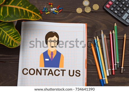 Notebook with a notes Contact US on the office table with tools. Business concept