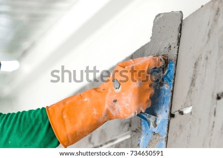 Construction worker wall plastering tools renovating apartment house. Construction finishing works.