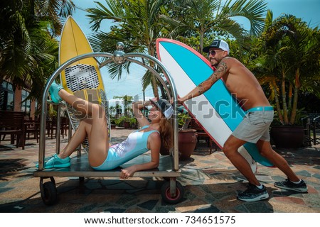 Boy and girl surfers having fun with surfboards
