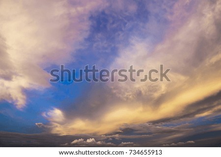 Dramatic atmosphere of blue sky and golden clouds on sunset background.