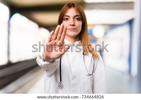 Young doctor woman making stop sign in the hospital