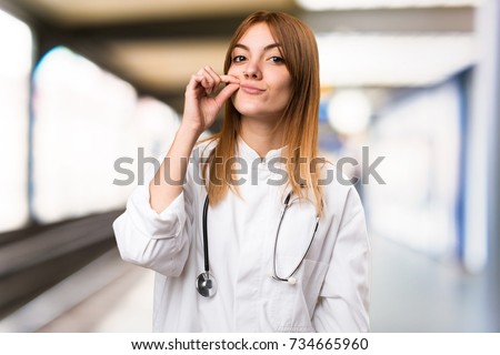 Young doctor woman making silence gesture in the hospital