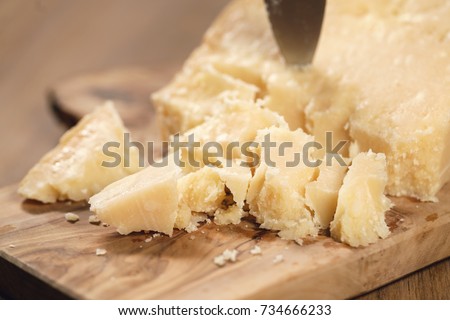 traditional grana padano italian cheese on olive board Royalty-Free Stock Photo #734666233
