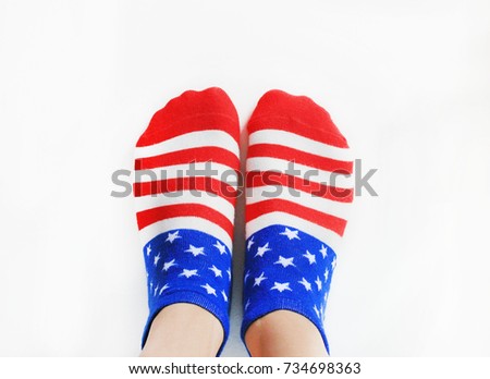 Person Wearing Socks with American Flag. Pair of cotton socks in red, blue and white color, United States flag pattern. Women and men fashion accessory isolated on white empty background copy space