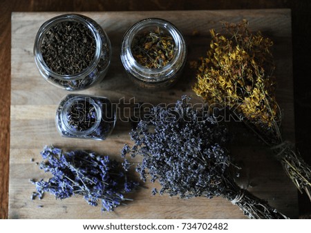 Preparation of herbal teas and dried flowers on a wooden board, cozy mood