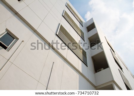 Modern building with window shutters and  reflection of the sun