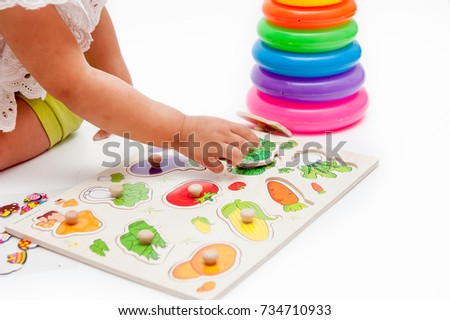 Little girls are learning with Wooden board with picture fruit.
