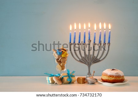 image of jewish holiday Hanukkah background with traditional spinnig top, menorah (traditional candelabra) and burning candles