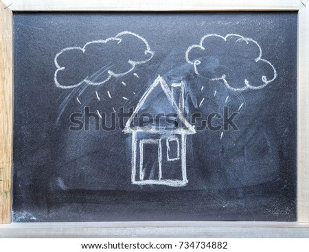 House and clouds with rain chalk hand drawn on the middle of a blackboard with frame. Copy space for your text.