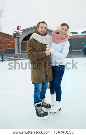 Cheerful affectionate dates in skates and winterwear spending leisure together