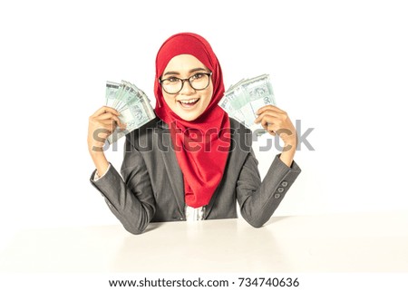 Hijab businesswoman smiling while holding money. Financial concept.
