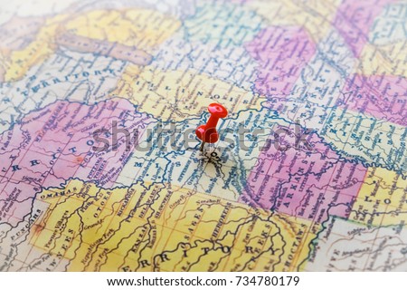Map of USA with a red pushpin stuck. Close-up of several color pushpin on a geographic map. The choice of the route.