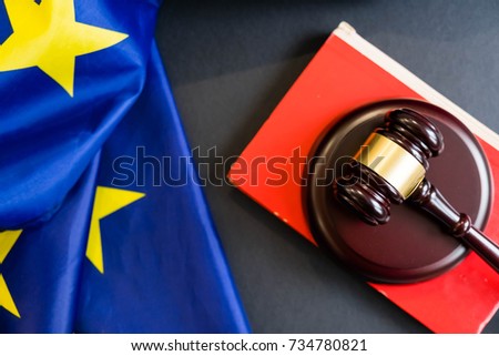 Judges wooden gavel with EU flag in the background. Symbol for jurisdiction. Wooden gavel on european union flag Royalty-Free Stock Photo #734780821